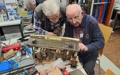 Zwei Männer schrauben und arbeiten an einem Elektrogerät.