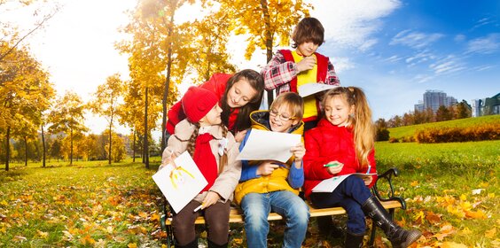 Kinder und Jugendliche auf einer herbstlichen Wiese.