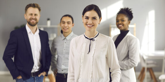 Portrait of happy beautiful business woman together with team of diverse employees