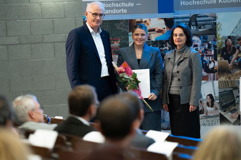 Ein Mann und zwei Frauen stehen auf der Bühne.