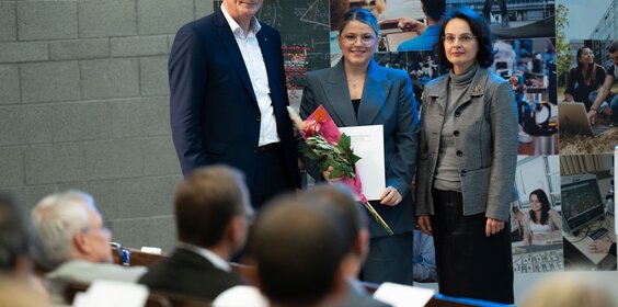 Ein Mann und zwei Frauen stehen auf der Bühne.