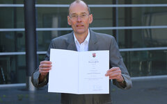Prof. Dr. Mathias Graumann mit der Dankensurkunde des Landes Rheinland-Pfalz
