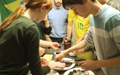 Erasmus-Studierende bereiten gemeinsam mit den Schülerinnen und Schülern des Franziskus Gymnasiums Nonnenwerth die brasilianische Süßspeise „Brigadeiro“ vor.