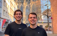 Zwei Männer stehen zusammen vor dem Kölner Dom.