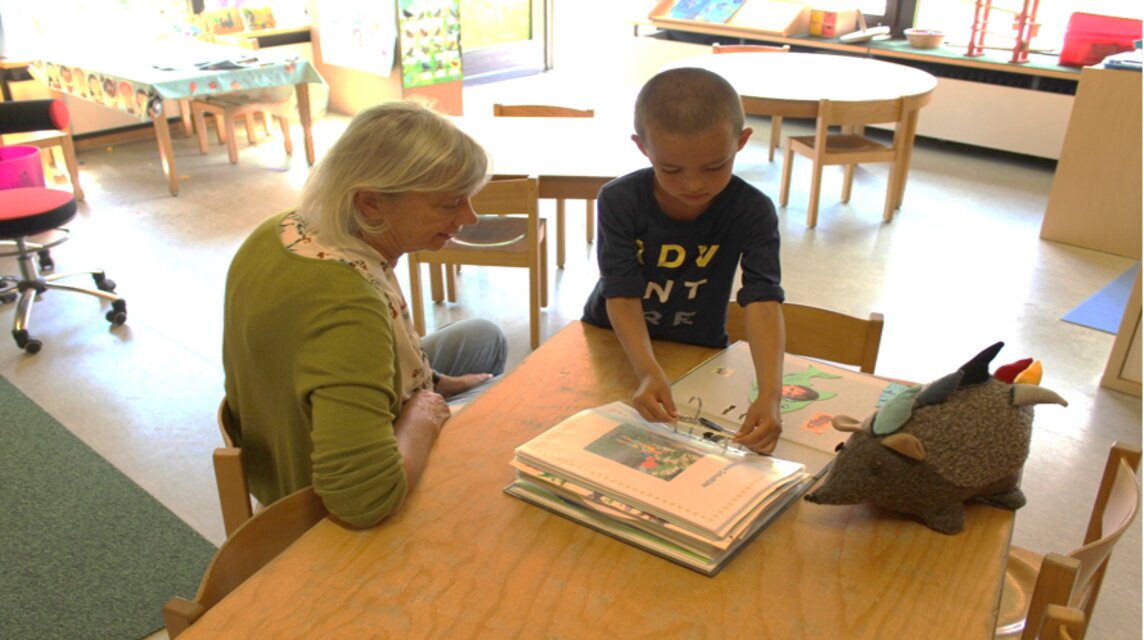 Kita Kind und Ebbi das Maskottchen lesen ein Buch