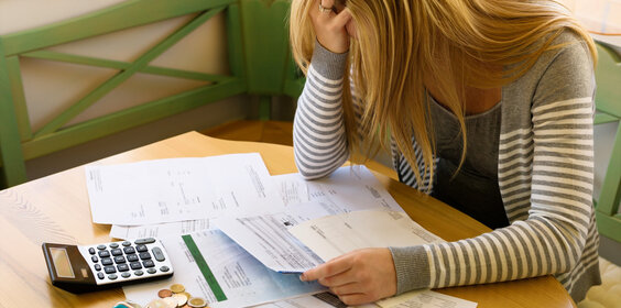 Studentin sitzt verzweifelt über ihren Rechnungen