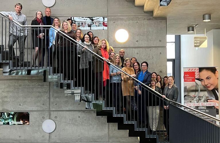 Frauen und Männer auf einer Treppe.