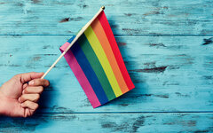 man waving a small rainbow flag